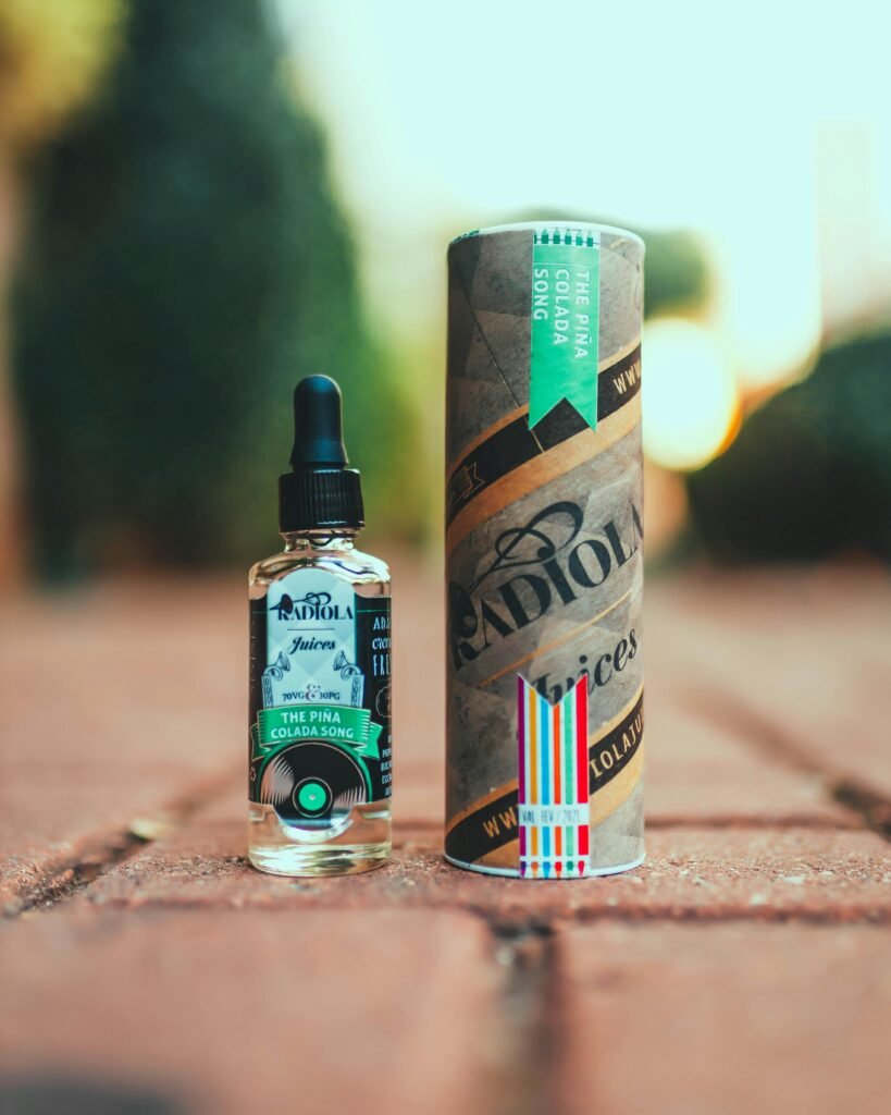 pexels-photo-13870352-13870352 Close-up of a Pina Colada vape juice bottle with packaging outdoors.