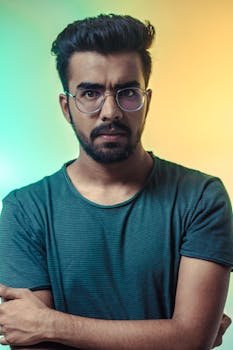 pexels-photo-1516680-1516680-1 A thoughtful adult man with eyeglasses posing for a portrait with a vibrant backdrop.