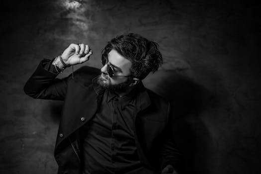 pexels-photo-432059-432059 Black and white portrait of a fashionable man in sunglasses and suit posing confidently indoors.